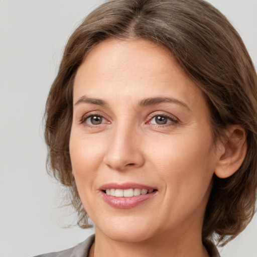 Joyful white adult female with medium  brown hair and grey eyes