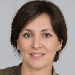 Joyful white adult female with medium  brown hair and grey eyes