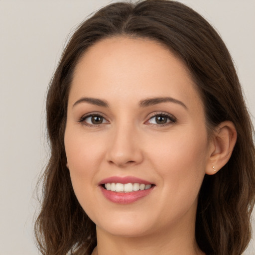 Joyful white young-adult female with long  brown hair and brown eyes