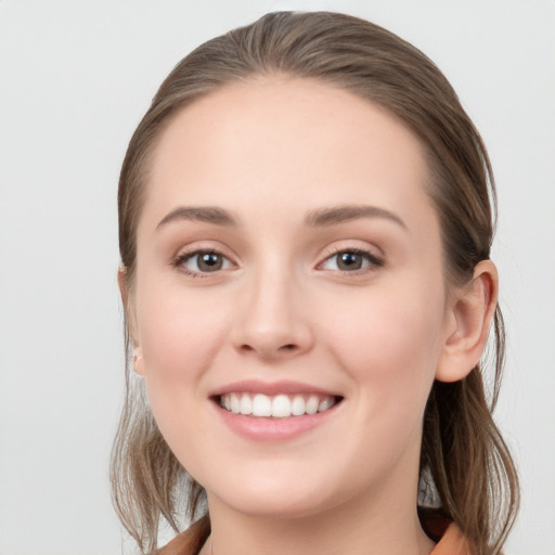 Joyful white young-adult female with long  brown hair and grey eyes