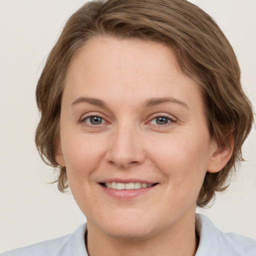 Joyful white young-adult female with medium  brown hair and blue eyes