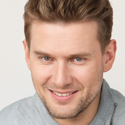 Joyful white adult male with short  brown hair and grey eyes