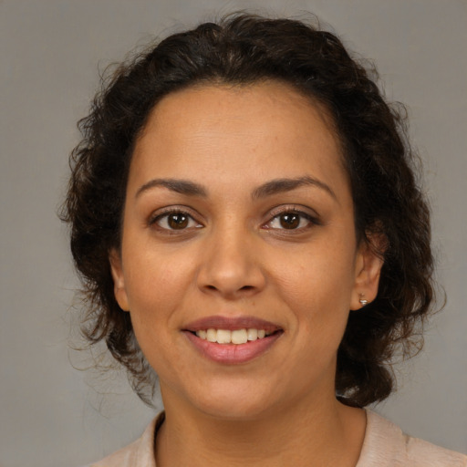 Joyful latino adult female with medium  brown hair and brown eyes