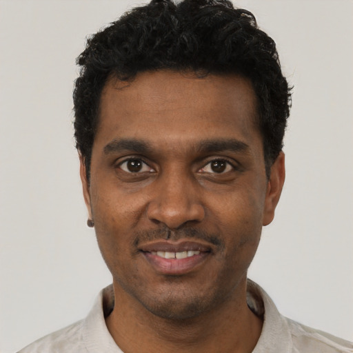 Joyful black young-adult male with short  black hair and brown eyes