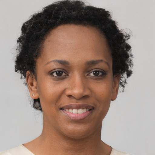 Joyful black young-adult female with short  brown hair and brown eyes