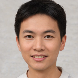 Joyful asian young-adult male with short  brown hair and brown eyes