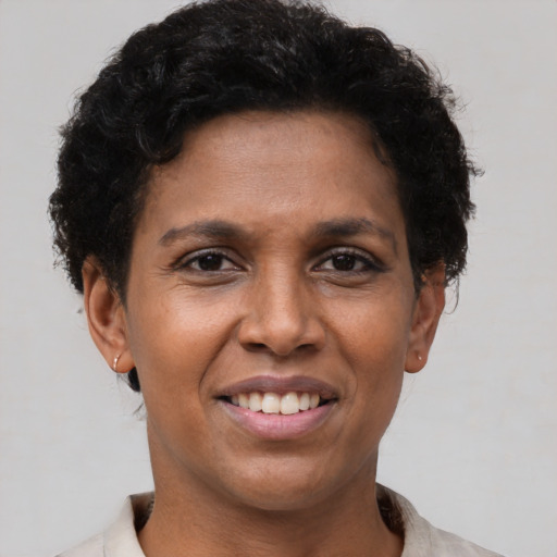 Joyful black young-adult female with short  brown hair and brown eyes