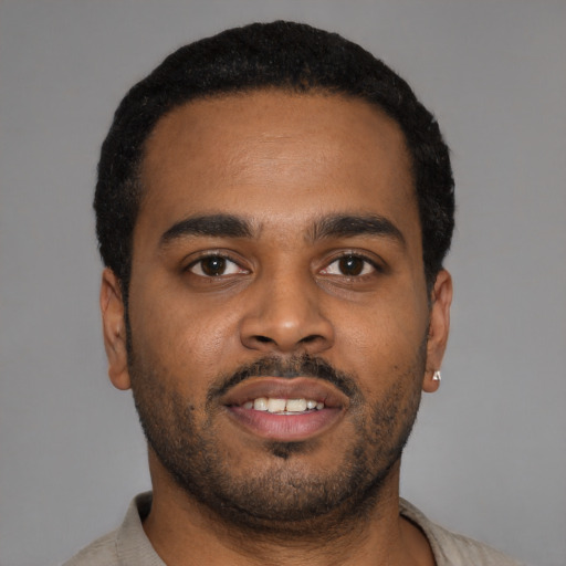Joyful latino young-adult male with short  black hair and brown eyes