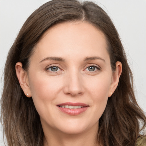 Joyful white young-adult female with long  brown hair and grey eyes