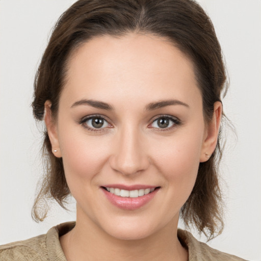 Joyful white young-adult female with medium  brown hair and grey eyes