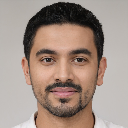 Joyful latino young-adult male with short  black hair and brown eyes