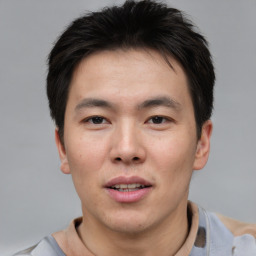 Joyful asian young-adult male with short  brown hair and brown eyes