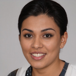 Joyful latino young-adult female with medium  brown hair and brown eyes