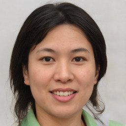 Joyful asian young-adult female with medium  brown hair and brown eyes