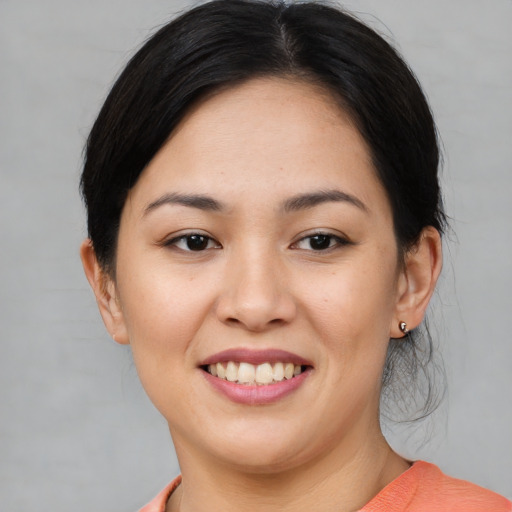 Joyful asian young-adult female with short  black hair and brown eyes