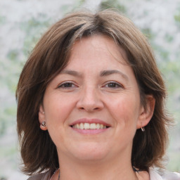 Joyful white adult female with medium  brown hair and grey eyes