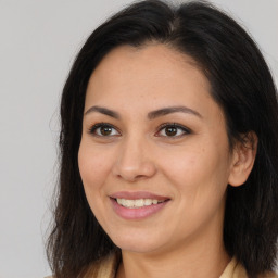 Joyful latino young-adult female with long  brown hair and brown eyes