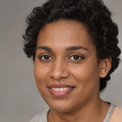 Joyful black young-adult female with short  brown hair and brown eyes