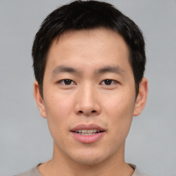 Joyful asian young-adult male with short  brown hair and brown eyes