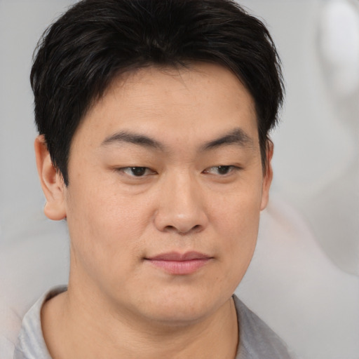 Joyful asian young-adult male with short  brown hair and brown eyes