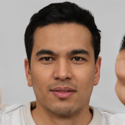 Joyful latino young-adult male with short  black hair and brown eyes