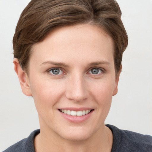 Joyful white young-adult female with short  brown hair and grey eyes