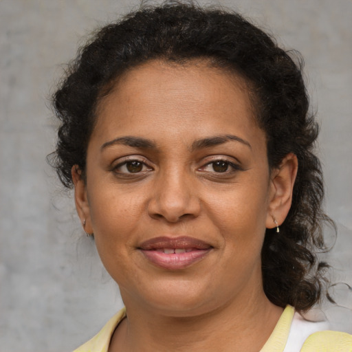 Joyful black adult female with medium  brown hair and brown eyes