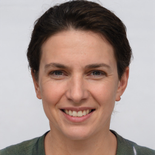 Joyful white young-adult female with short  brown hair and grey eyes