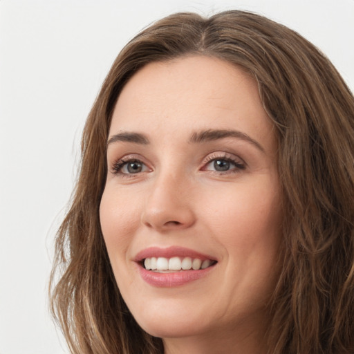 Joyful white young-adult female with long  brown hair and green eyes