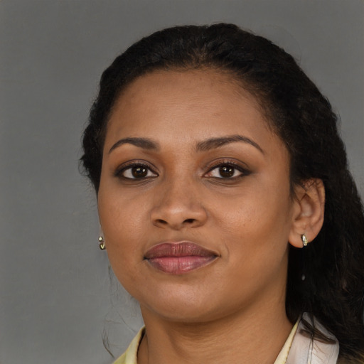 Joyful black young-adult female with long  brown hair and brown eyes