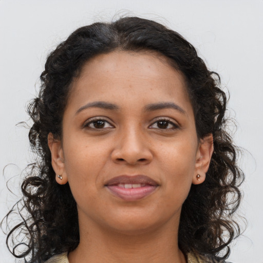 Joyful black young-adult female with long  brown hair and brown eyes