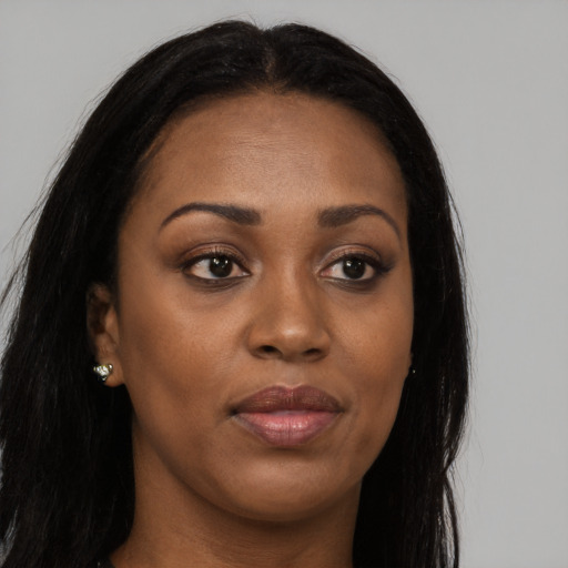 Joyful black young-adult female with long  brown hair and brown eyes