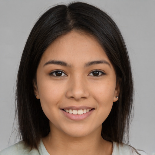 Joyful latino young-adult female with long  brown hair and brown eyes