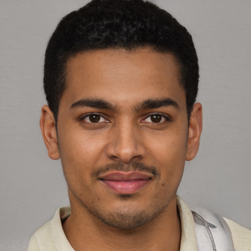 Joyful black young-adult male with short  brown hair and brown eyes