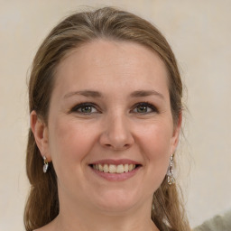 Joyful white young-adult female with medium  brown hair and grey eyes