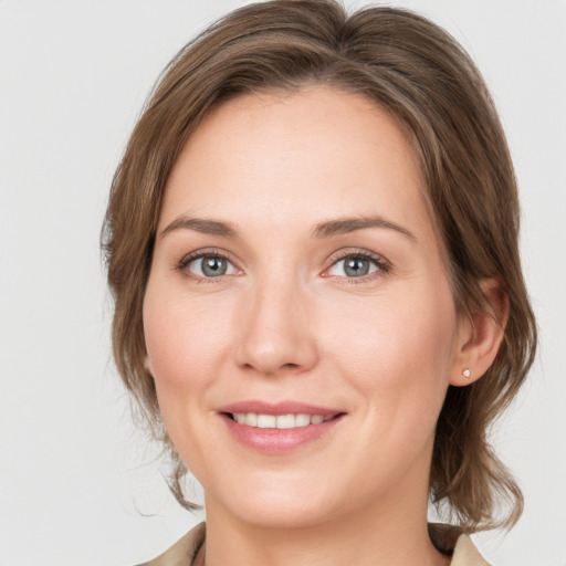 Joyful white young-adult female with medium  brown hair and grey eyes