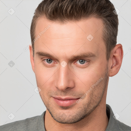 Joyful white young-adult male with short  brown hair and brown eyes