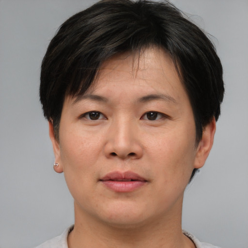 Joyful asian adult female with short  brown hair and brown eyes