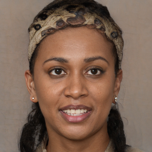 Joyful black young-adult female with long  black hair and brown eyes