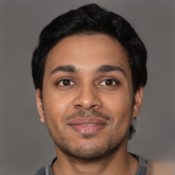 Joyful latino young-adult male with short  brown hair and brown eyes