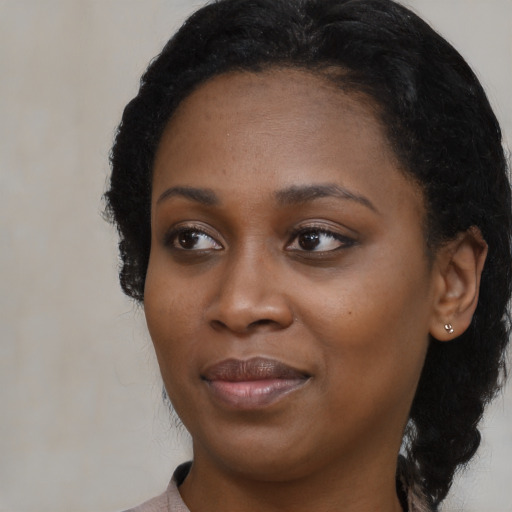 Joyful black young-adult female with long  black hair and brown eyes