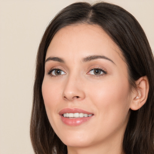 Joyful white young-adult female with long  brown hair and brown eyes