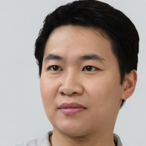Joyful asian young-adult male with short  black hair and brown eyes