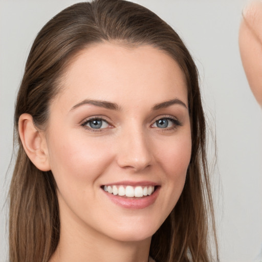 Joyful white young-adult female with long  brown hair and grey eyes