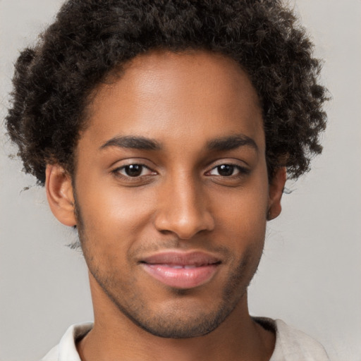 Joyful black young-adult male with short  brown hair and brown eyes