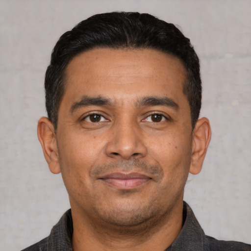 Joyful latino young-adult male with short  black hair and brown eyes