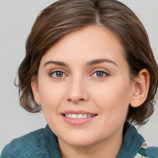 Joyful white young-adult female with medium  brown hair and blue eyes