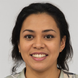 Joyful latino young-adult female with medium  brown hair and brown eyes