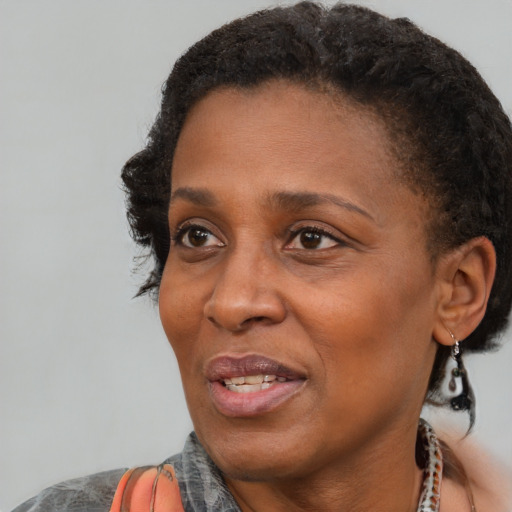 Joyful black adult female with short  black hair and brown eyes