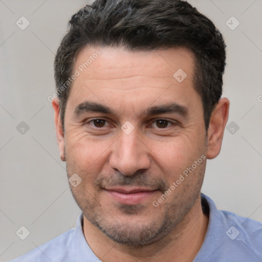 Joyful white adult male with short  black hair and brown eyes